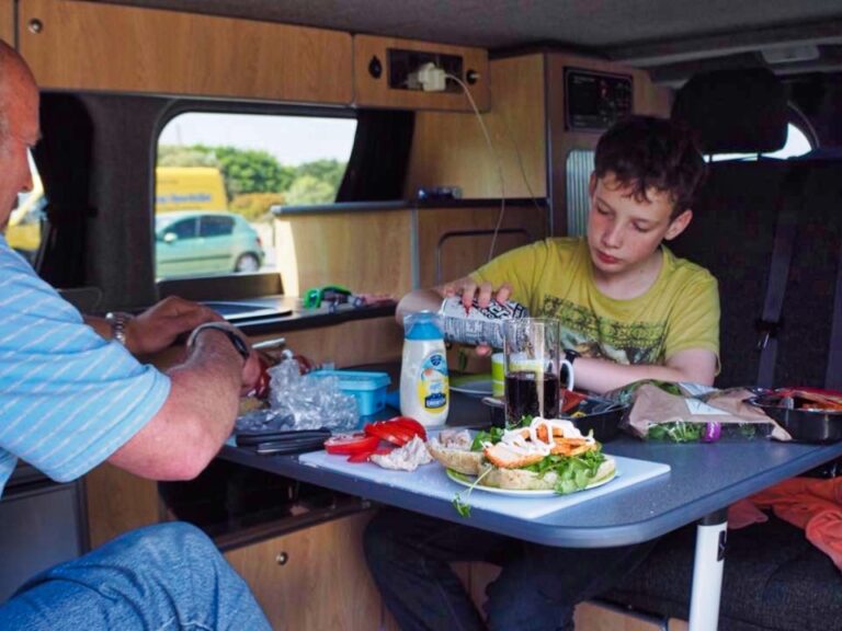 family eating snacks inside their campervan
