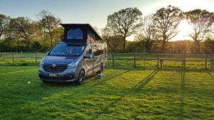 Grey campervan parked under sunset