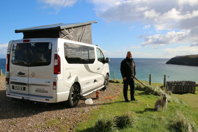 man with his dog outside their campervan