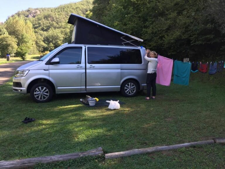 silver campervan with clothes hanging outside